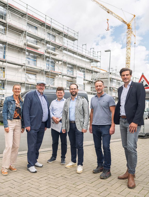 Sechs Personen vor einer Baustelle