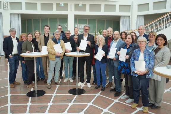 Das Bündnis arm_in_Arm übergibt das sozialpolitische Forderungspapier an den Oberbürgermeister im Beisein vieler Ratsvertreter*innen